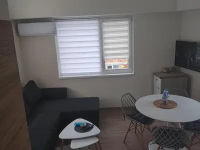 a living room with a couch and a table at Apartment SUN RAYS Nesebar in Nesebar
