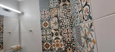 a bathroom with a tiled wall with different colored tiles at Studio GALILEO in Burgas City