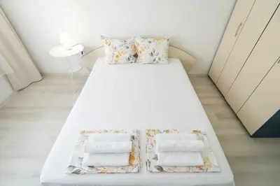 a white bed with two pillows on it in a room at Римски Терми Варна in Varna City