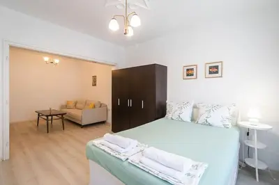 a bedroom with a large bed and a living room at Римски Терми Варна in Varna City