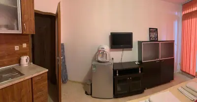 a kitchen with a small refrigerator and a television at Stamopolu Parter in Primorsko