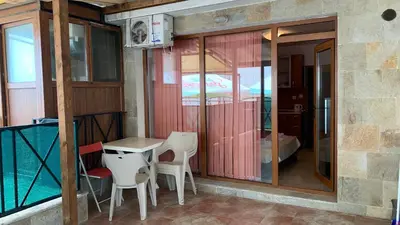 a room with a table and chairs and a balcony at Stamopolu Parter in Primorsko