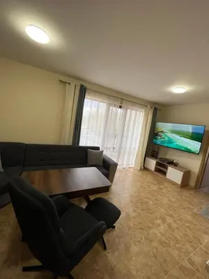 a living room with a couch and a table and a tv at River park 2 bedroom apartment in Nesebar