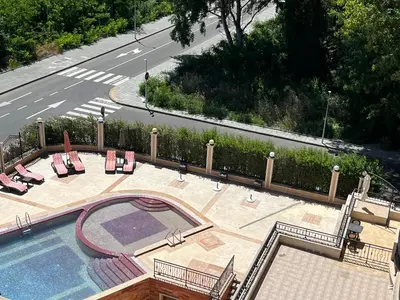 an overhead view of a swimming pool with chairs and a road at River park 2 bedroom apartment in Nesebar