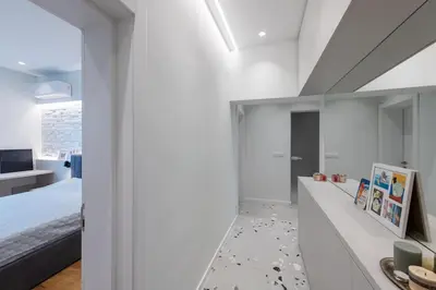 a bedroom with a bed and a white wall at Modern & Stylish Sea Apartment with Parking in Burgas City