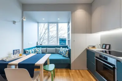 a small kitchen and living room with a blue couch at Modern & Stylish Sea Apartment with Parking in Burgas City