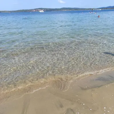 a body of water with the sand and the water at Апартамент на плаж Градина in Chernomorets