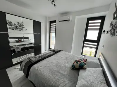 a bedroom with a large bed and two windows at Marino Liberta South Beach Obzor in Obzor