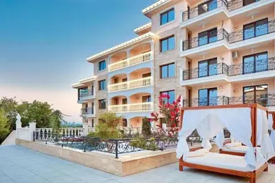 a large apartment building with two beds in front of it at Valencia Gardens - Private apartment - BSR in Nesebar