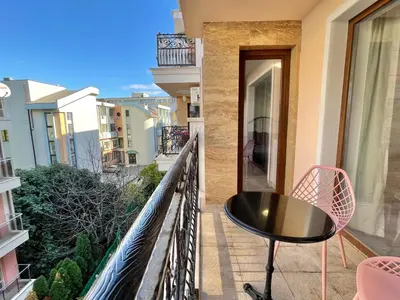 a balcony with a table and chairs on a balcony at Valencia Gardens - Private apartment - BSR in Nesebar
