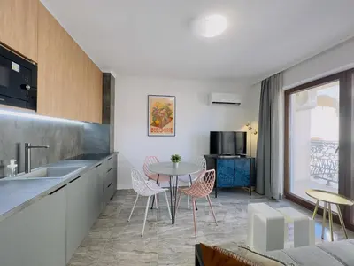 a kitchen and dining room with a table and chairs at Valencia Gardens - Private apartment - BSR in Nesebar