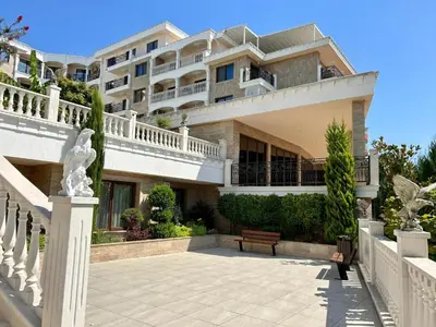 a large building with a bench in front of it at Valencia Gardens - Private apartment - BSR in Nesebar