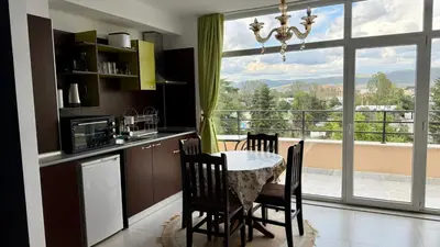 a kitchen with a table and chairs and a large window at Top Studio in Big Kamelia Holiday Complex Sunny Beach in Sunny Beach