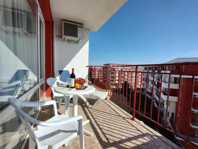 a table and chairs on a balcony with a bottle of wine at Studio Robinson Beach Sea Nessebar View in Sveti Vlas