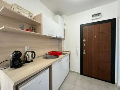 a small kitchen with a sink and a wooden door at HORIZON Apartment 8,1 'A' Sveti Vlas in Sveti Vlas
