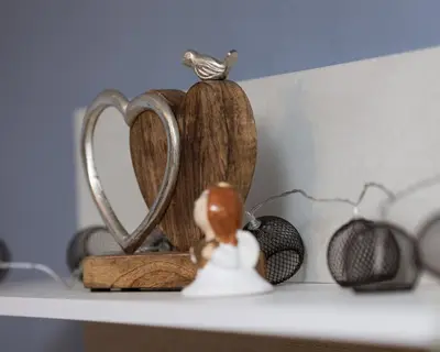 a toy doll sitting on a shelf with a heart ornament at Happy Lazur in Burgas City