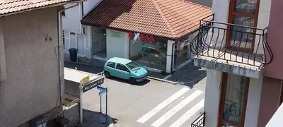 a small blue car parked on a street next to a building at Anchors Guest House in Sozopol