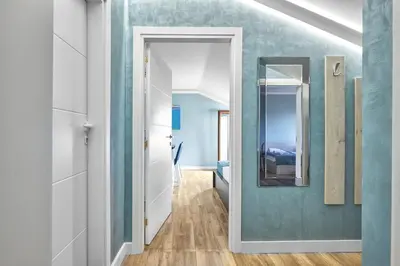 a hallway with a mirror and a blue wall at Perfect Seaside Retreat in Sveti Vlas Relax Complex by Flat Mаnаger in Sunny Beach