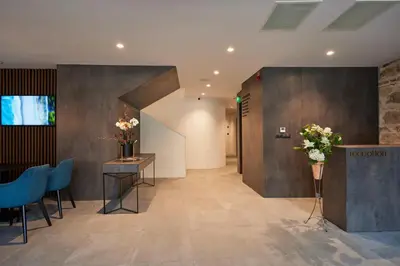 a lobby with blue chairs and a table with flowers at Bizarre Boutique Hotel in Varna City