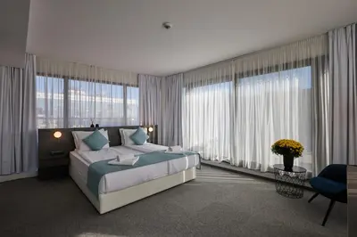 a bedroom with a large bed and large windows at Bizarre Boutique Hotel in Varna City