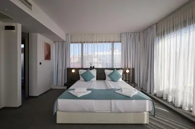 a large bedroom with a large bed and large windows at Bizarre Boutique Hotel in Varna City