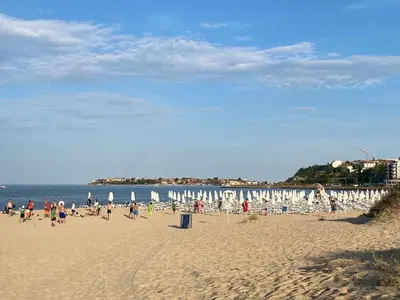 a group of people on a beach with chairs and umbrellas at KASANDRA 'Д' 5 Apartment Sunny Beach in Sunny Beach
