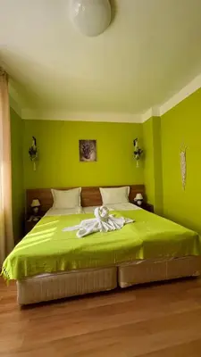 a green bedroom with a bed with a towel on it at KASANDRA 'Д' 5 Apartment Sunny Beach in Sunny Beach