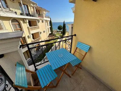 a balcony with two blue chairs and a table at HORIZON 19 'A' APARTMENT Sveti Vlas in Sveti Vlas