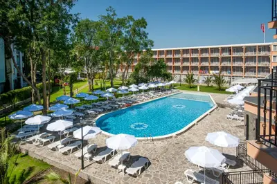 a swimming pool with chairs and umbrellas and a hotel at Hotel Riva - All Inclusive in Sunny Beach