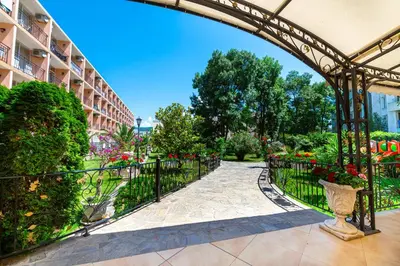 a walkway in a park with a fence and flowers at Hotel Riva - All Inclusive in Sunny Beach