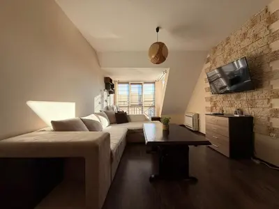 a living room with a couch and a tv at Home by the Sea in Burgas City