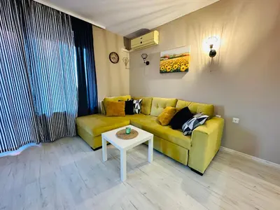 a living room with a yellow couch and a table at Blue Marine - Daneli Apartment in Sunny Beach
