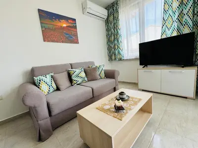 a living room with a couch and a tv at HORIZON 34 'Б-' Apartment Sveti Vlas in Sveti Vlas