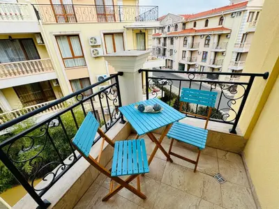 a balcony with two blue chairs and a table at HORIZON 26 'Б' Apartment Sveti Vlas in Sveti Vlas