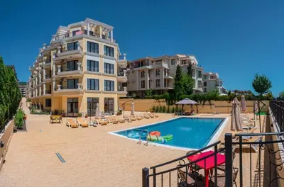 a hotel with a swimming pool next to a building at HORIZON 25 'Б' Apartment Sveti Vlas in Sveti Vlas