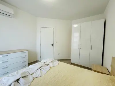 a white bedroom with a bed and a dresser at HORIZON 20 'Б' Apartment Sveti Vlas in Sveti Vlas