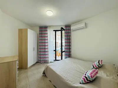 a bedroom with a bed and a window with curtains at HORIZON 20 'Б' Apartment Sveti Vlas in Sveti Vlas
