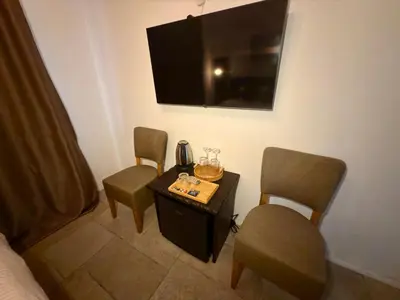a room with two chairs and a table and a tv at Arthotel Oscar II Sozopol in Sozopol
