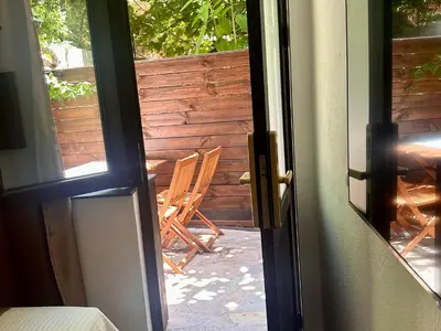 an open door to a patio with a rocking chair at Arthotel Oscar II Sozopol in Sozopol