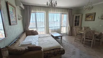 a bedroom with a large bed and a table and chairs at Luxury Sea Sunset Deluxe Apartment in Burgas City