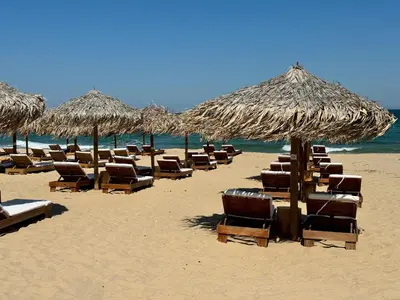 a group of chairs and umbrellas on a beach at Sunshine apartment in Shkorpilovtsi