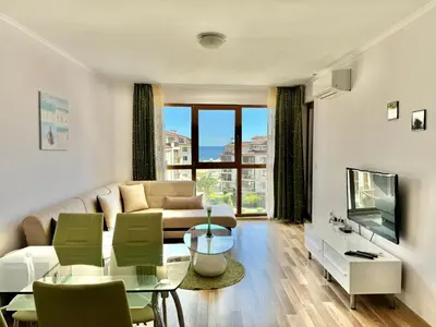 a living room with a couch and a table at Sunshine apartment in Shkorpilovtsi