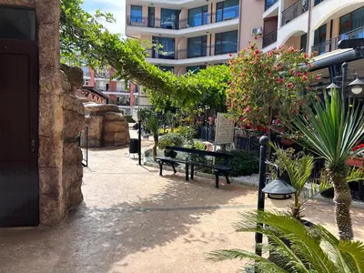 a courtyard with a bench and a building at Karolina Apartment 65 in Sunny Beach
