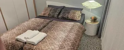 a bed with two towels on it in a room at Апартамент ЛазуР in Burgas City