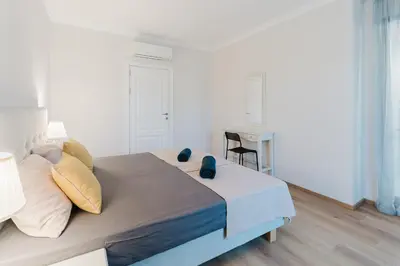 a bedroom with a bed with a table and a desk at Sozopol Созопол MORE SUN 2 Б Sozopolis in Sozopol