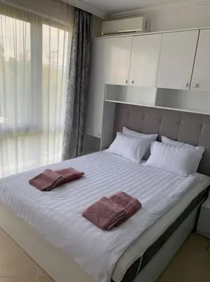 a large white bed with two towels on it at Двуспални апартаменти Оазис Бийч клуб in Lozenets