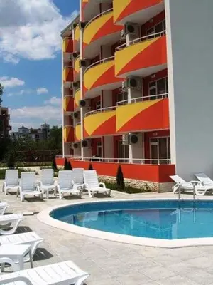 a hotel with a pool and chairs and a building at Студия в центре Солнечного берега in Sunny Beach