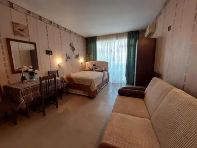 a living room with a couch and a bed at Студия в центре Солнечного берега in Sunny Beach
