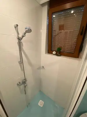 a bathroom with a shower and a window at Sozopol Santa Marina Sea View Studio in Sozopol