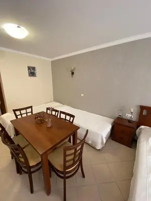a room with a dining table and two beds at Sozopol Santa Marina Sea View Studio in Sozopol